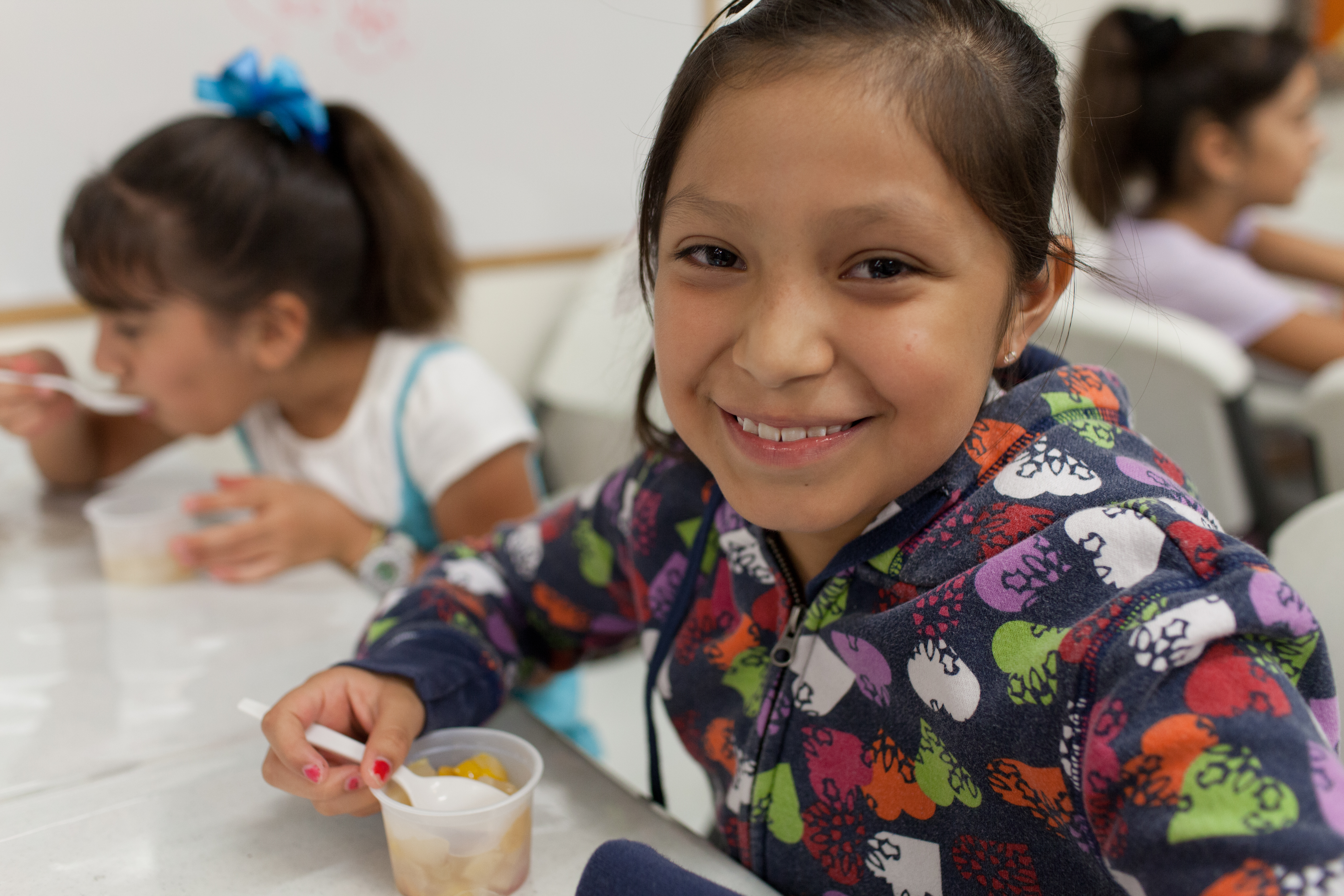 Two girls eating breakfast at school